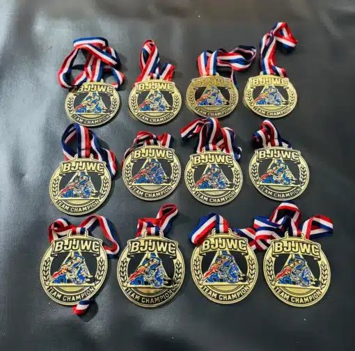 Multiple custom BJJ medals with red, white, and blue lanyards for tournament winners