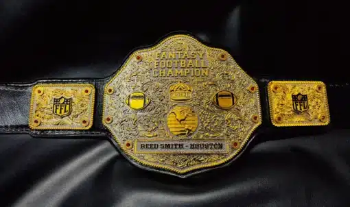 Close-up of the FFL Championship Belt featuring intricate gold engraving, customizable side plates, and red gemstone detailing.