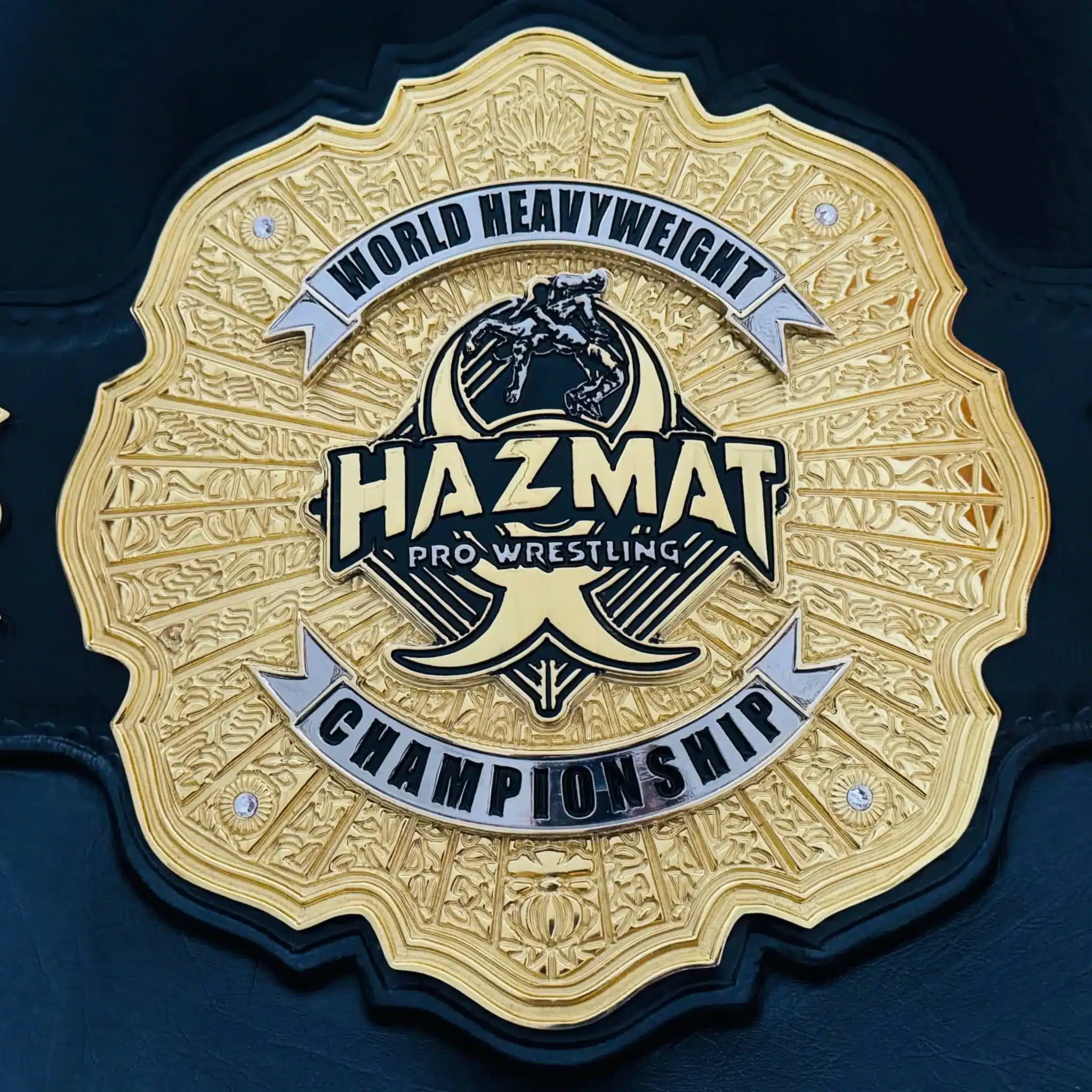 Close-up of custom world heavyweight style wrestling belt with detailed engraving and raised 3D logo