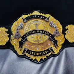 Close-up of a custom corporate championship belt with engraved logo on a multi-layered gold plate.