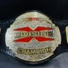 Detailed close-up of the TNA X Division Championship Belt highlighting the genuine leather strap and chrome accents.