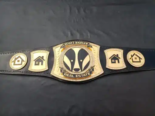 A full-length image of a real estate championship belt, featuring gold plating, custom engraving, and a leather strap for durability.