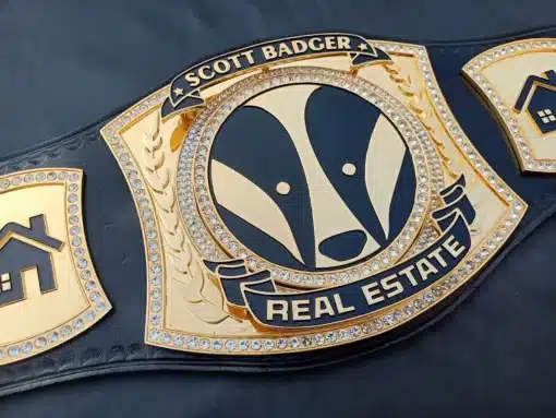 Detailed view of the spinner center plate on a custom real estate championship belt, featuring gold plating, deep engraving, and a luxury design.