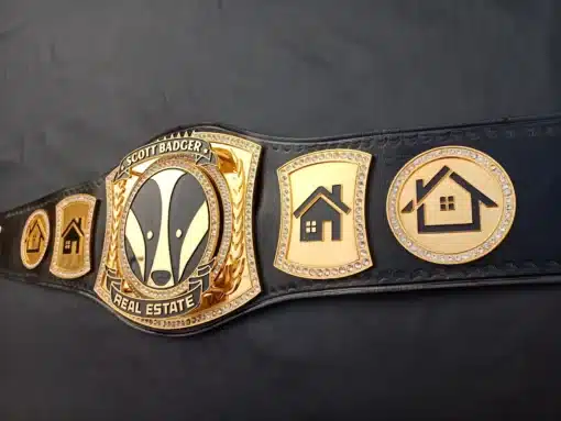 Close-up of the stacked banners on the gold-plated real estate championship belt, allowing custom text engraving for branding or achievements.