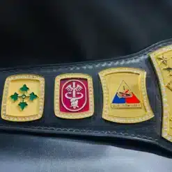 Engraved military unit side plates on a custom Army championship belt, showcasing division insignia and gold detailing.