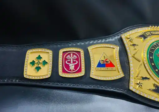 Engraved military unit side plates on a custom Army championship belt, showcasing division insignia and gold detailing.