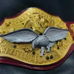 Stunning silver eagle centerpiece on a gold championship belt with vintage wrestling artwork.