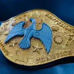 A side angle shot of the NWA Canadian Heavyweight Championship belt, highlighting the deep engravings and raised gold details.