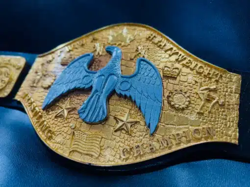 A side angle shot of the NWA Canadian Heavyweight Championship belt, highlighting the deep engravings and raised gold details.