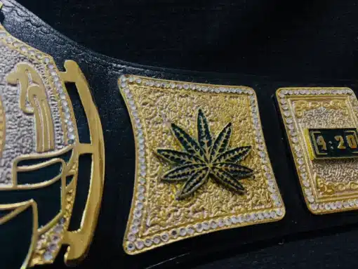 Detailed gold etching and cannabis-themed artwork on the championship belt.