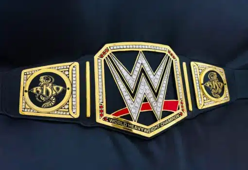 WWE belt replica with clear and red gem stones on gold-plated center and RKO side plates