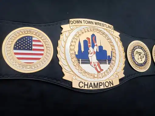 Octagonal main plate of wrestling belt showcasing engraved city skyline and in-ring action figure